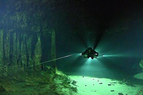 Cave explorer Bil Phillips, also a member of the Texas A&M-led team, uses a flashlight and line to navigate the underwater cave.