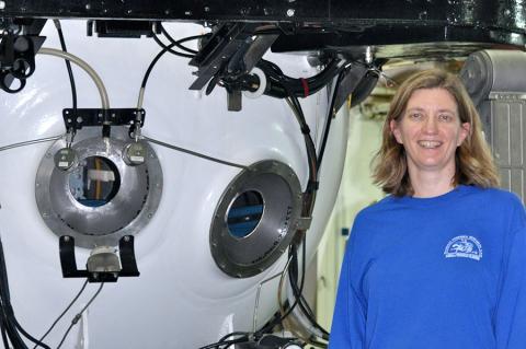 Associate Professor of Earth, Ocean and Atmospheric Science Amy Baco-Taylor, standing next to a submersible in which she has conducted research.
